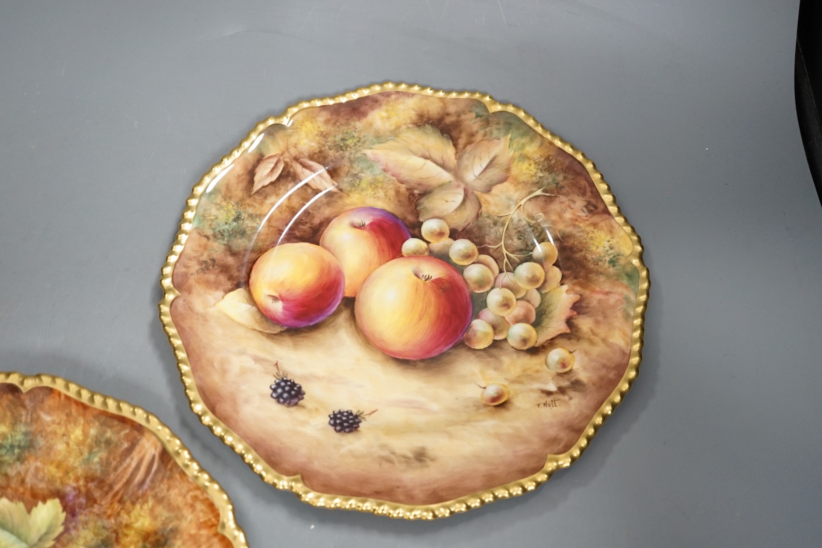 A pair of Royal Worcester fruit painted dinner plates, post war, by D. Shinnie and T. Nutt, 27cm diameter